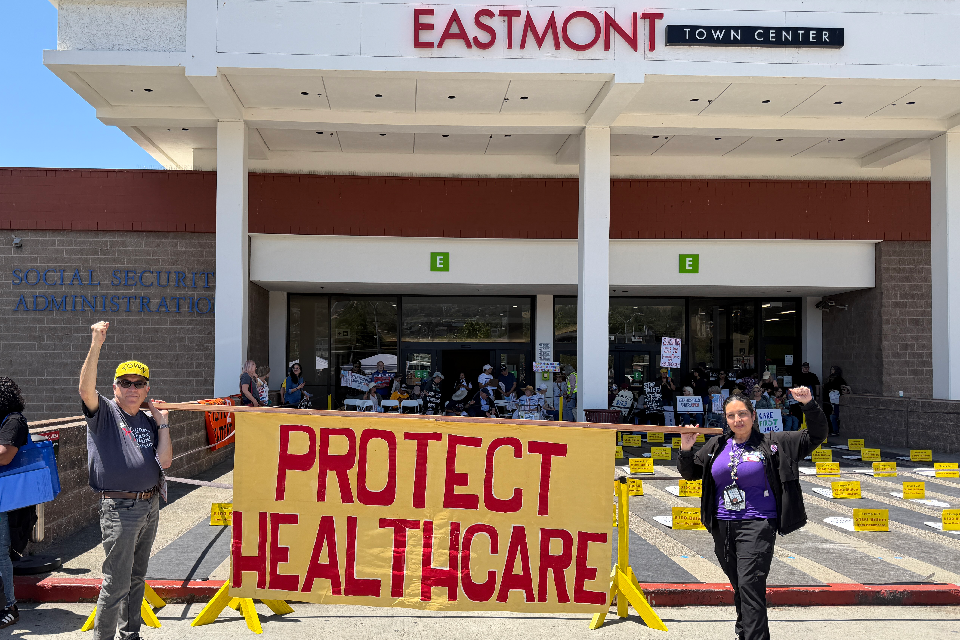 Members rally at a "die-in" for healthcare at Oakland's Eastmont Town Center.