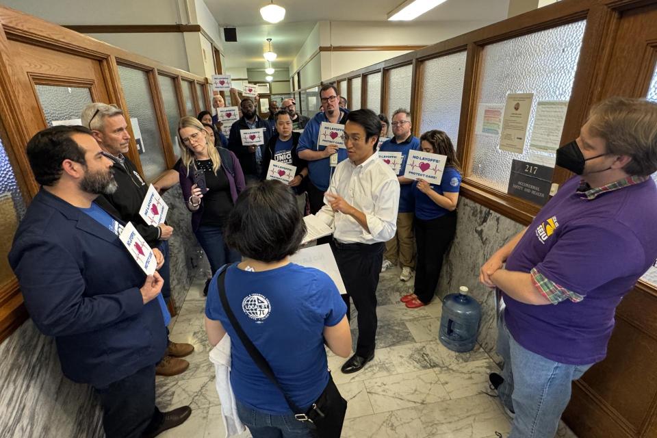 SEIU 1021 SFDPH member Brian Feraru presents the 1500 petition signatures to Director Daniel Tsai on Monday, March 23.